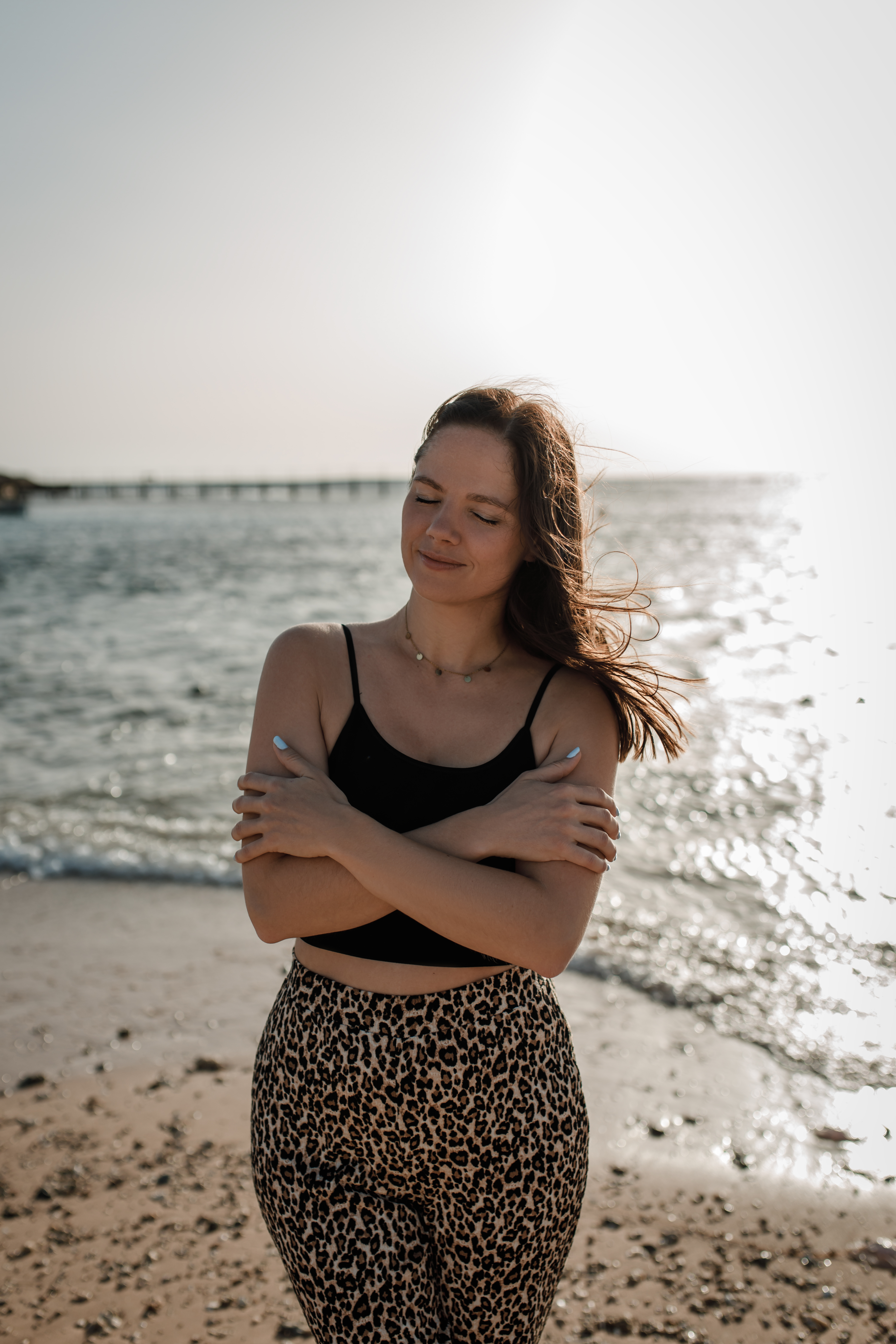 Sarah am Meer, die sich selbst umarmt